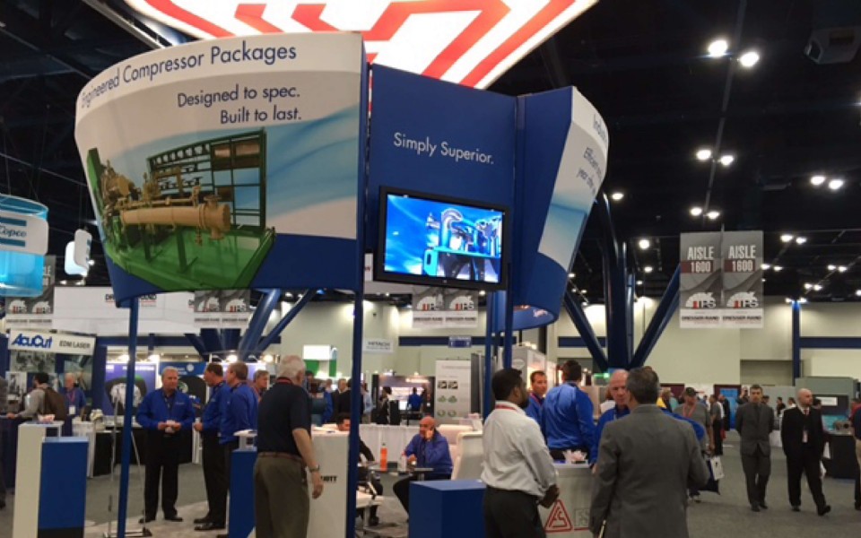 FS-Elliott trade show booth featuring industrial compressor displays, promotional signage, and attendees networking at an industry exhibition.